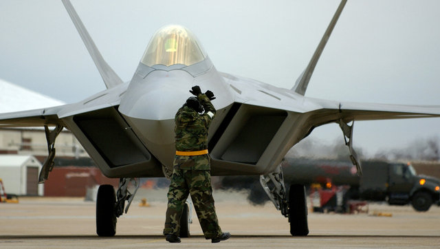 Staff Sgt. Adam Murtishaw, a crew chief assigned to the 27th Aircraft Maintenance Unit, marshals in an F-22A "Raptor" after a late day sortie at Langley Air Force Base, Virginia Dec. 14, 2005.  The 27th Fighter Squadron reaches Initial Operating Capability (IOC) Dec. 15, 2005.  (U.S. Air Force photo by TSgt. Ben Bloker)